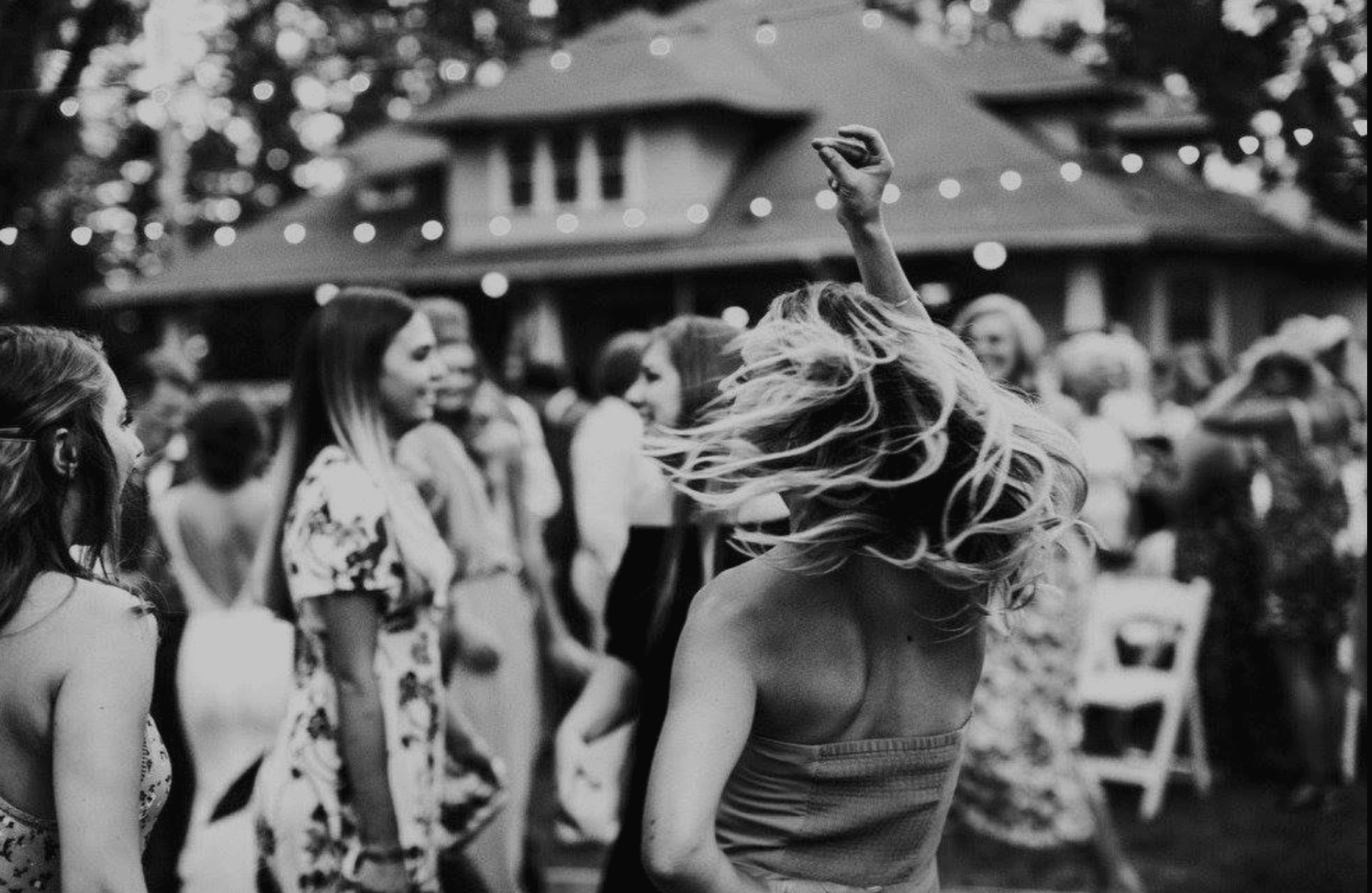 A group of women dancing joyfully at an outdoor party.